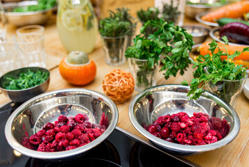 fresh raspberries in metal bowls on a wooden table, closeup