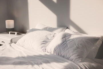 White soft pillows on bed in room