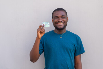 close up of a handsome african man from nigeria holding his voters card