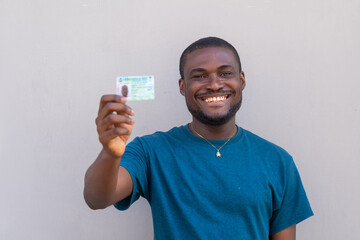 close up of a handsome african man from nigeria holding his voters card