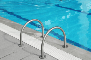 Ladder with handrails in outdoor swimming pool