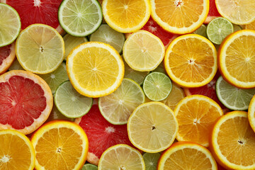Fototapeta na wymiar Different citrus fruits as background, top view