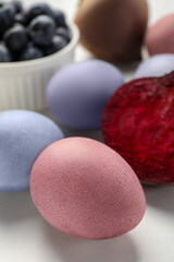 Fototapeta na wymiar Colorful Easter eggs painted with natural dyes on white table, closeup