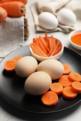 Naturally painted Easter eggs on light grey table, closeup. Carrot used for coloring
