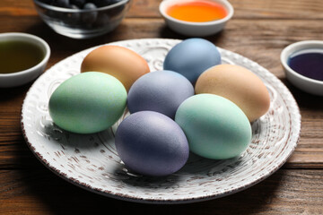 Easter eggs painted with natural organic dyes on wooden table, closeup