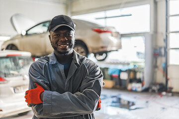 Afro-American serviceman posing for a photo in a auto repair shop, medium shot. High quality photo