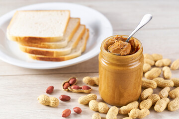 Concept Breakfast for vegetarians, peanut butter and peanut beans on wooden table.