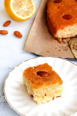 Basbousa or namoora traditional arabic semolina cake with cashew nuts and syrup. Selective focus.