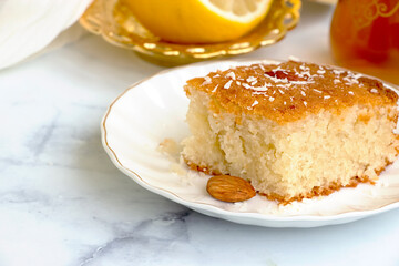 Basbousa or namoora traditional arabic semolina cake with cashew nuts and syrup. Selective focus.
