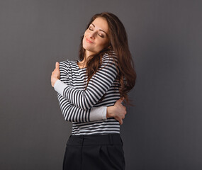 Obraz premium Beautiful happy smiling woman hugging herself with love