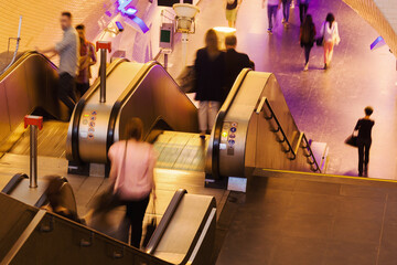 escalators to an underground station with blurred people