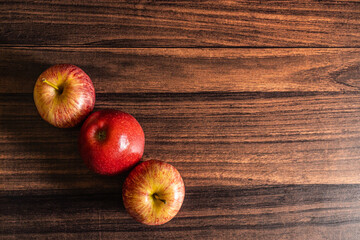 Ripe red color apples kept on a wooden table with copy space 