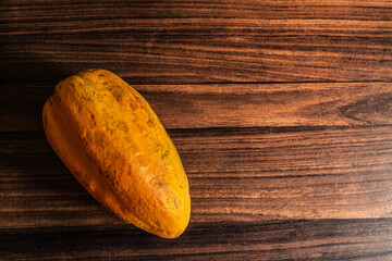A fresh ripe organic papaya kept on a wooden table. Food photography