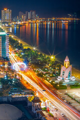 Fototapeta na wymiar Elevated view of a busy road at night between high city buildings and a beach at Nha Trang in Vietnam
