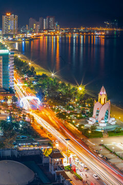 Elevated view of a busy road at night between high city buildings and a beach at Nha Trang in Vietnam