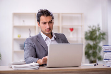 Young male employee and too much work in the office