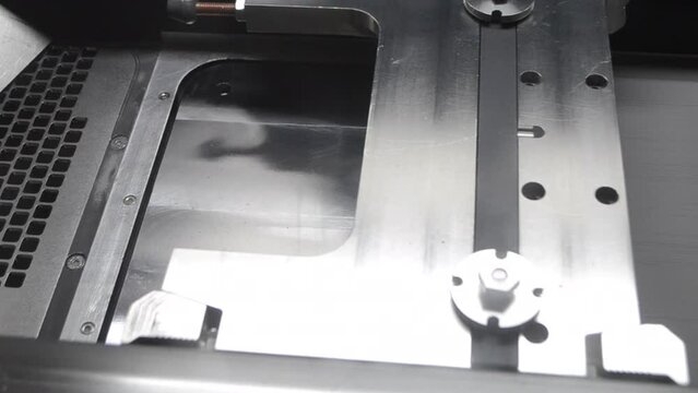 Alignment of metal powder on working surface of 3D printer for metal before starting work. Gray material metal powder for printing objects by 3d printer for metal. Working 3d printer inside.