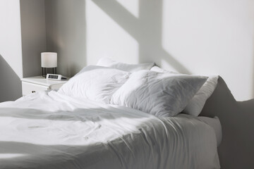 Fototapeta na wymiar White soft pillows on bed in room