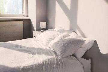 White soft pillows on bed in room