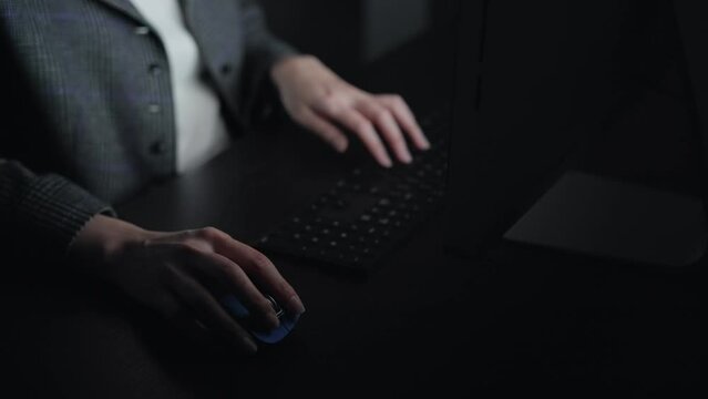 暗い部屋でパソコンを使う女性