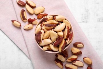 Delicious Brazil nuts on white table, flat lay