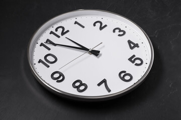 Fototapeta na wymiar Clock showing five minutes until midnight on black table. New Year countdown