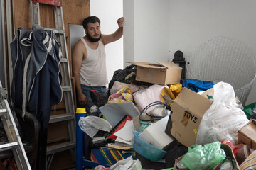 hoarding compulsive person standing looking at the mess in his room