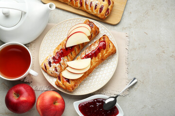 Fresh tasty puff pastry with jam and apples served on white textured table, flat lay. Space for text