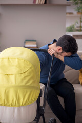 Young male contractor looking after baby at home