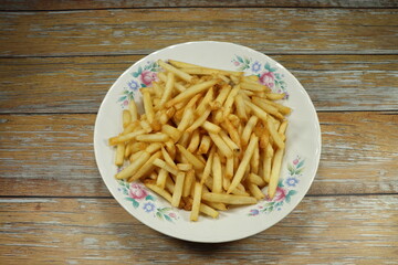 Deep fried French fries (Potato chip) serving on the plate. Famous appetizer menu in restaurant. Fast food concept.