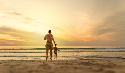 Father and son running on the beach  - obrazy, fototapety, plakaty