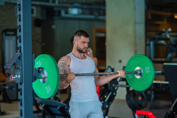 Fototapeta na wymiar Fit guy doing exercise at gym. Handsome sporty man workout with with dumbbells on gym. Male athlete with dumbbell on fitness workout. Fitness man in gym. Muscular sportsman workout with weight in gym.