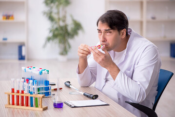 Young male chemist working at the lab