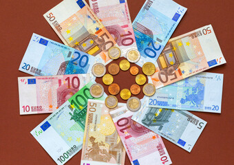 Flat lay of euro banknotes of different denominations and euro cents coins in сenter. Financial business background. Concept of payment for services, social payments, market, loans, economy, inflation
