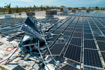 Aerial view of damaged by hurricane wind photovoltaic solar panels mounted on industrial building...