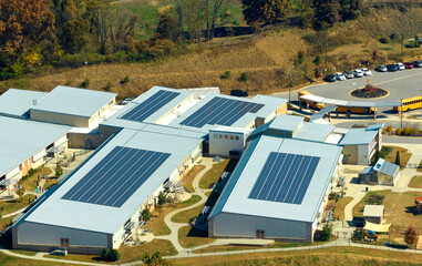 View from above of american school campus with roof covered with photovoltaic solar panels for...
