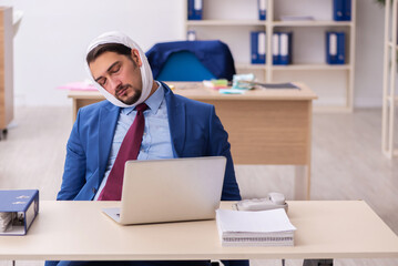 Young male employee suffering from toothache at workplace