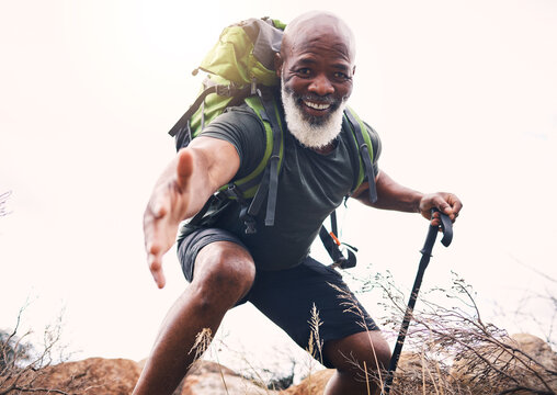Hiking, help and portrait of senior man reaching hand during hike, fitness and cardio in nature on light background. Helping, hands and face of elderly guy offering support while trekking in a forest - Powered by Adobe
