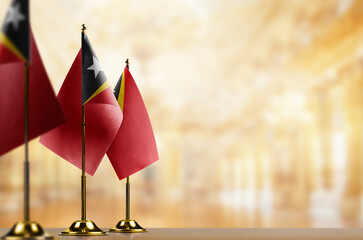 Small flags of the East Timor on an abstract blurry background