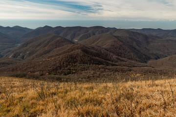 View from a great height in a picturesque place of the Caucasus. The mountain range of the Caucasus against the background of clouds. Beautiful mountain landscape.