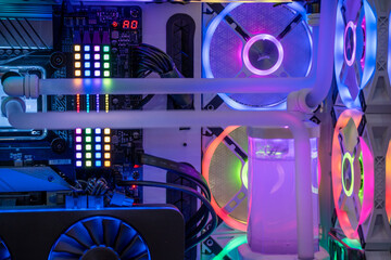 shot of overclocked CPU computer cabinet with water liquid cooled processors and RGB red green blue lighting with metal pipes running
