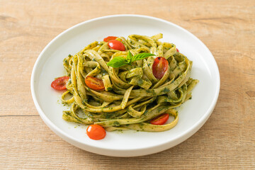 fettuccine spaghetti pasta with pesto sauce and tomatoes