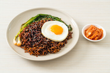 dried Korean spicy black sauce instant noodles with fried egg and kimchi