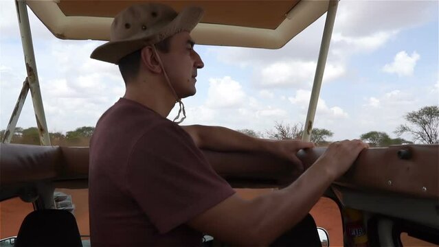 man on jeep driving trough african savannah, safari tour, green nature landscape, kenya, tsavo east