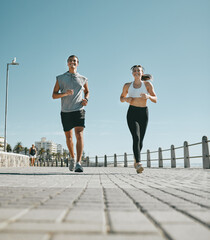Couple, fitness and running by beach in the city for exercise, workout or cardio routine together....