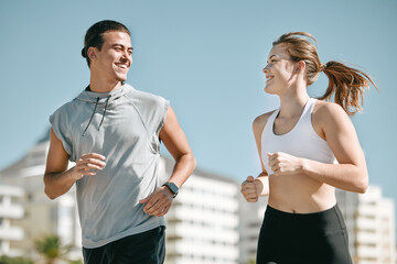Couple, fitness and smile running in the city for exercise, workout or cardio routine together in...