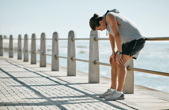 Fitness, tired and breathing man for cardio training, workout or outdoor running break at beach. Breathe, thinking and fatigue of athlete or sports person with exercise challenge in summer by ocean