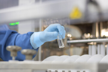 a hand in a medical latex glove holds a glass ampoule for vaccines Medical Glass vials