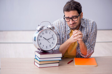 Young male student in time management concept