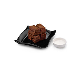 croutons on a black plate with garlic sauce on a white background isolated